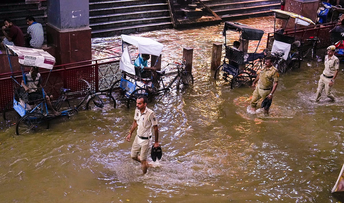 PTI : Police personnel wade through a waterlogged road at Karol Bagh metro station during rain, in New Delhi, Wednesday, July 31, 2024. 
